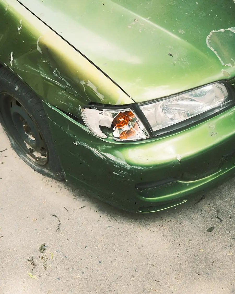 Auto verde con el frente abollado